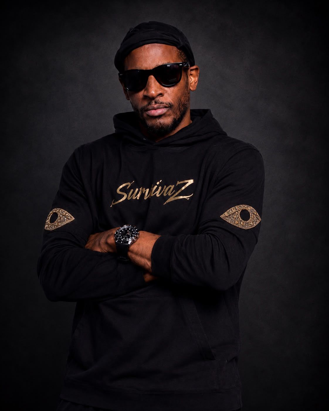Black hoodie with gold SurvivaZ script on the chest and gold eye patches on the sleeves.